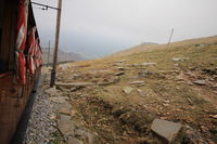 Vue de l’extérieur d’un wagon du petit train de la Rhune à l’approche du sommet