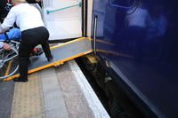 Embarquement d’un fauteuil roulant à bord du train de nuit Caledonian Sleeper, en gare de London Euston, Angleterre